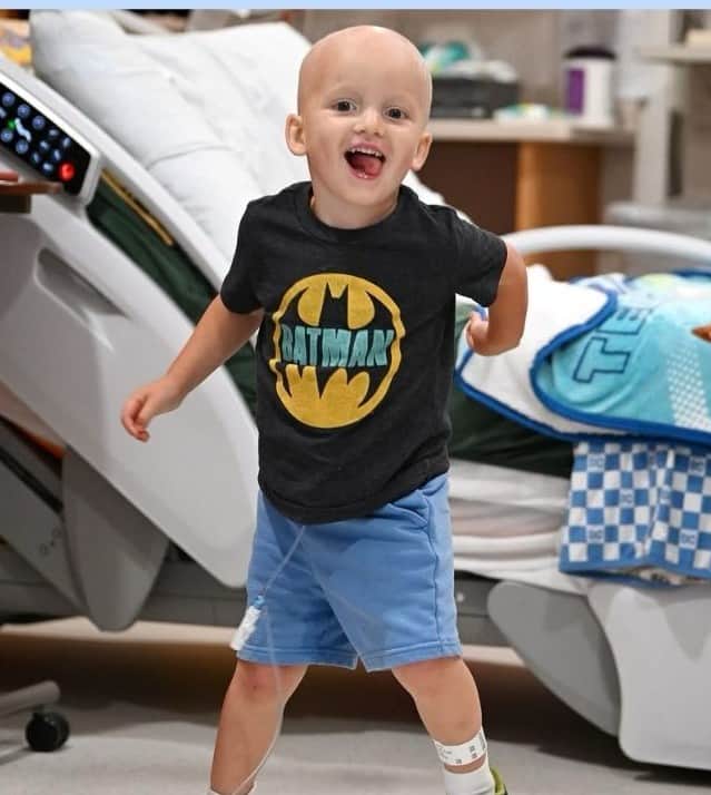 Cody in a Batman shirt, mid-stride in his room at Riley Hospital for Children